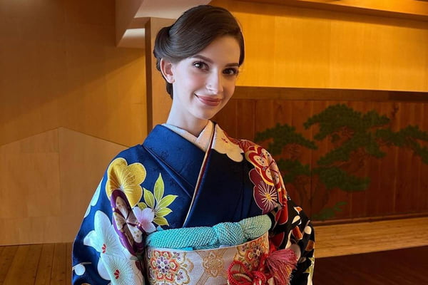 foto colorida de mulher branca de cabelos castanhos sorrindo de boca fechada vestida em trajes tradicionais japoneses - metrópoles