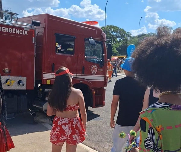 Imagem de caminhão dos bombeiros entrando em avenida onde acontecia bloco de Carnaval sendo observado por foliões - Metrópoles