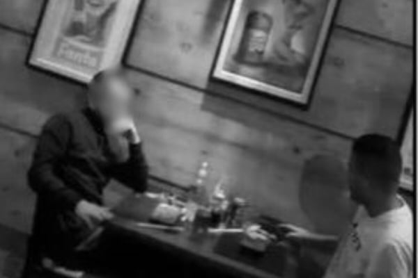 Schwarz-Weiß-Bild von zwei Männern, die sich an einem Bäckereitisch gegenübersitzen – Metrópoles