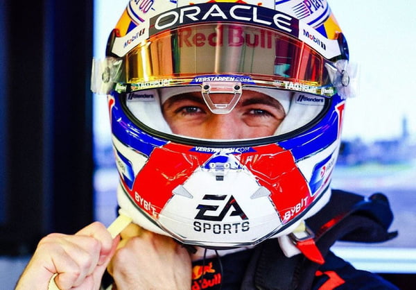 Imagem colorida mostra o piloto Max Verstappen afivelando o capacete