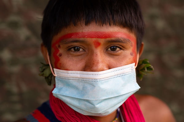 Foto colorida de indígena Yanomami de máscara em atendimento do governo - Metrópoles