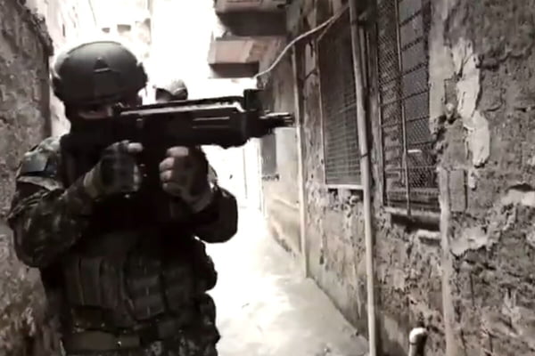 PM fardado aponta fuzil em meio de favela na Baixada Santista durante operação da PM - Metrópoles