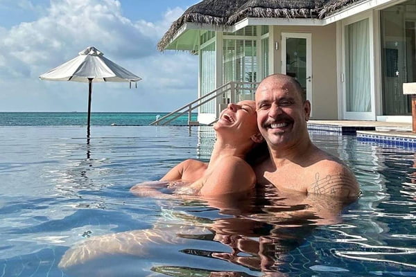 Foto colorida da atriz Paolla Oliveira com o cantor Diogo Nogueira. Os dois estão rindo e abraçados dentro de uma piscina - Metrópoles