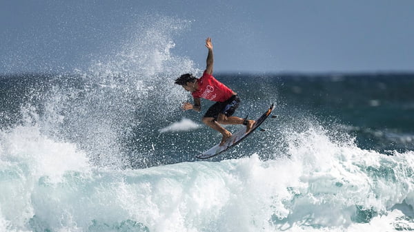 Foto mostra o surfista Gabriel Medina saindo de uma onda usando uma roupa vermelha - Metrópoles