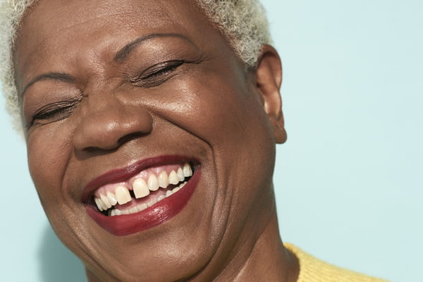 Imagem mostra close do rosto de uma mulher negra sorrindo - Metrópoles