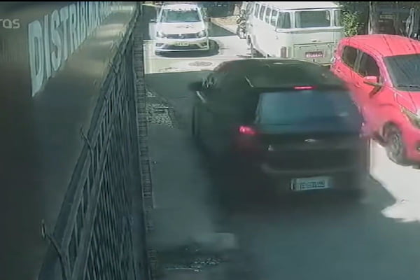 Print de vídeo em momento antes de viatura da PM branca bater de frente com carro preto em rua residencial