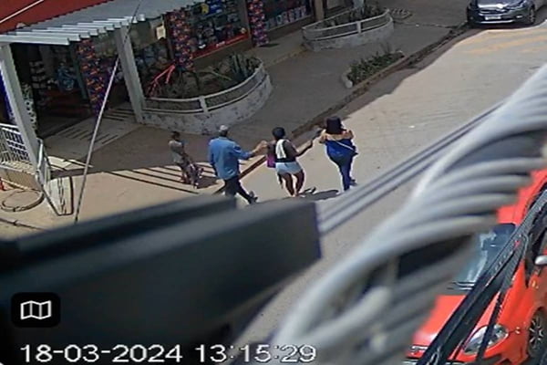 Imagem de criminosos levando a vítima pela rua