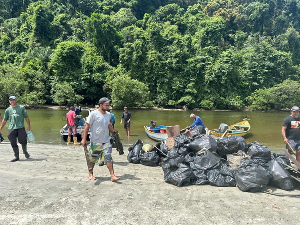 Homens na beira do mangue com sacos empilhados de lixo - Metrópoles