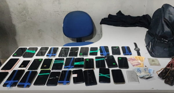 Imagem de mais de 30 celulares enfileirados sobre uma mesa - Metrópoles
