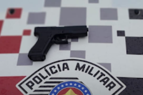 Imagem colorida de simulacro de arma de fogo em cima do capô da viatura da PM - Metrópoles