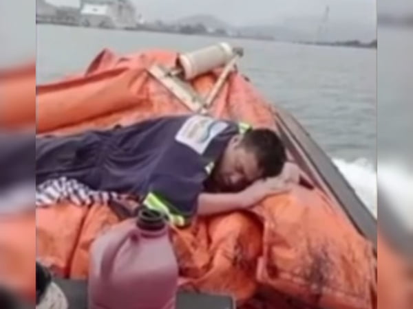 Imagem deitado sobre embarcação, coberto por manta - Metrópoles