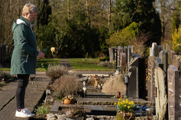 Uma pessoa visitando alguém no cemitério