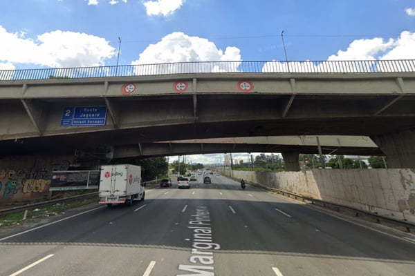 Imagem do Google Maps de ponte de concreto, a Ponte do Jaguaré, em trecho sobre a Marginal Pinheiros, em São Paulo. Um carro passa pela avenida e o céu está azul com nuvens.