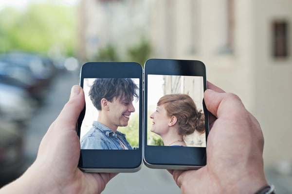Foto colorida de duas pessoas na tela do celular - Metrópoles