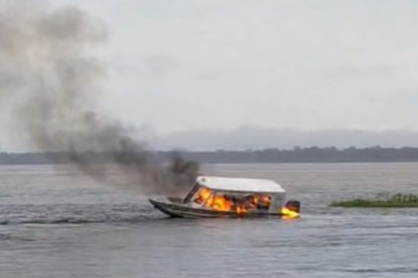 Foto mostra lancha que pegou fogo em Jutaí no Amazonas. Embarcação no meio da água arde em chamas enquanto coluna de fumaça sobe por conta do incêndio