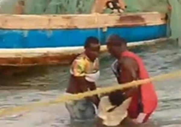 Foto de vítima sendo carregada no mar em naufrágio em Moçambique - Metrópoles