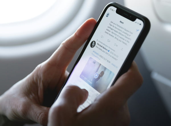 Fotografia colorida mostrando mão mexendo em celular dentro de avião-Metrópoles