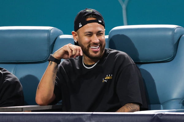 Imagem colorida de Neymar sentado sorrindo -Metrópoles