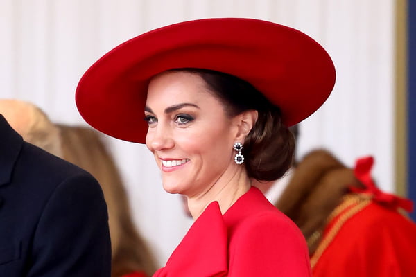 Foto colorida de mulher com chapéu e vestido vermelho - Metrópoles
