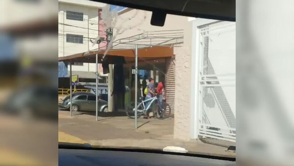 Foto colorida de homem furtando camisa. Furto foi filmado de dentro do carro por um motorista - Metrópoles