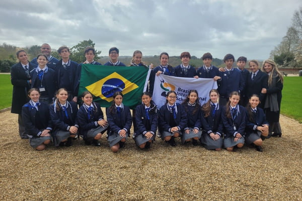 Imagem colorida de grupo de estudantes segurando bandeira do Brasil e da escola; alunos ganharam prêmio internacional - Metrópoles
