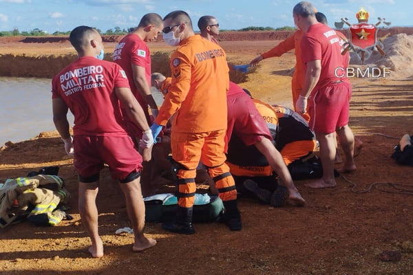 Foto colorida de bombeiros resgatando homem afogado