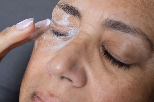 Foto colorida de uma mulher fazendo skincare - Metrópoles