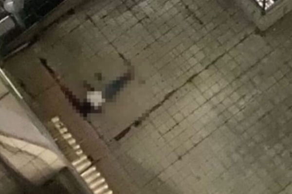 Imagem forte: corpo de homem com uma blusa branca no pátio de um prédio