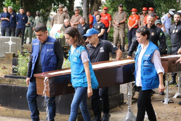 Imagem colorida mostra sepultamento de pessoas que estavam em embarcação encontrada à deriva - metropoles