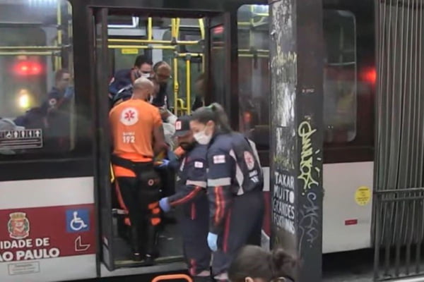 Imagem colorida com equipes de resgate dentro de ônibus com porta aberta. Metrópoles
