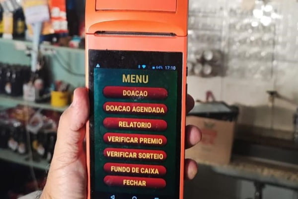 Imagem colorida de Máquina de cartão laranja. Metrópoles