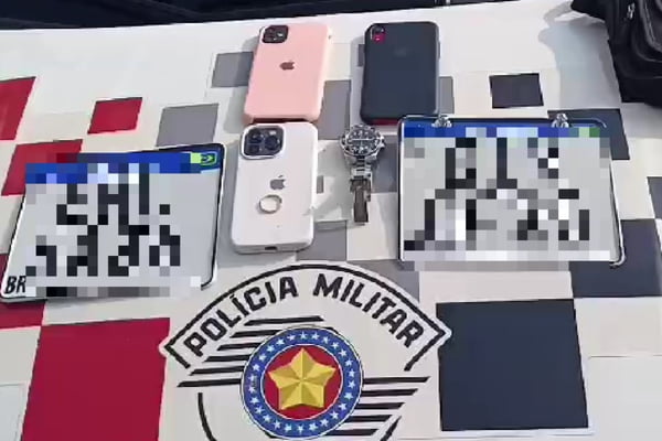 Imagem mostra relógio e celulares sobre símbolo da polícia - Metrópoles