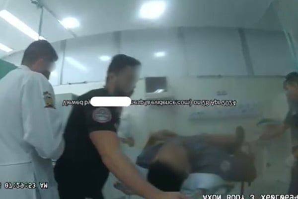 Imagem colorida de PM fardado sobre maca enquanto é atendido em hospital - Metrópoles