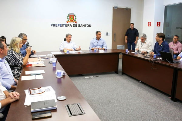 Imagem colorida de uma sala com pessoas reunidas. Metrópoles