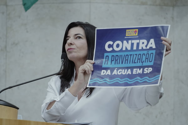 Imagem colorida mostra a vereadora Silvia Ferraro segurando um cartaz contra a privatização da sabesp; oposição entrou na Justiça contra a privatização - Metrópoles