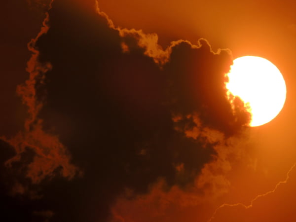 Imagem colorida de sol e nuvem - Metrópoles