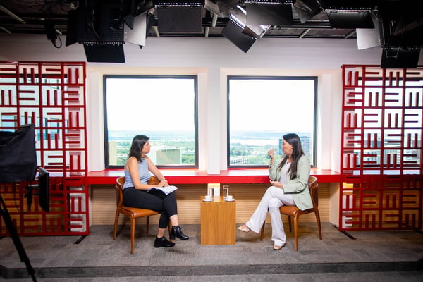 Foto colorida de secretária em entrevista. Mulher branca de cabelos longos e lisos