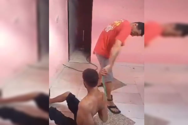 Imagem colorida de criminoso torturando homem a chicotadas em Pirenópoles - Metrópoles