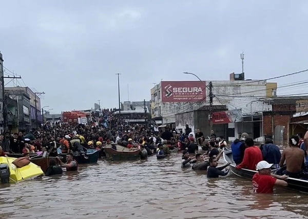 Foto colorida de pessoas em enchente na cidade de Canoas no Rio Grande do Sul - Metrópoles