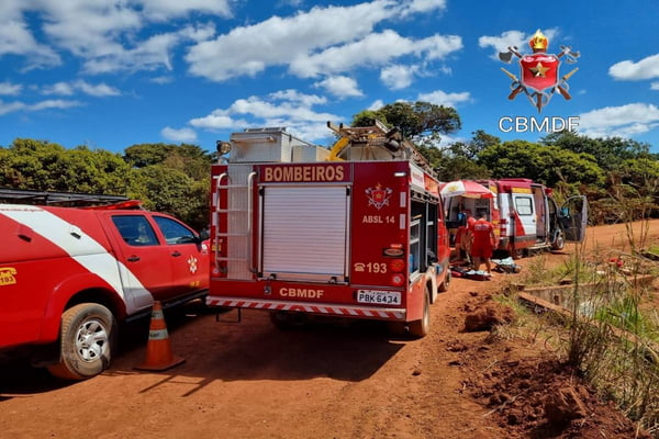 Foto colorida de viatura do bombeiro em local de barragem com céu azul