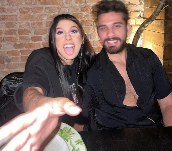 Ana Castela e Gustavo Mioto posam juntos em restaurante, ambos de looks pretos - Metrópoles