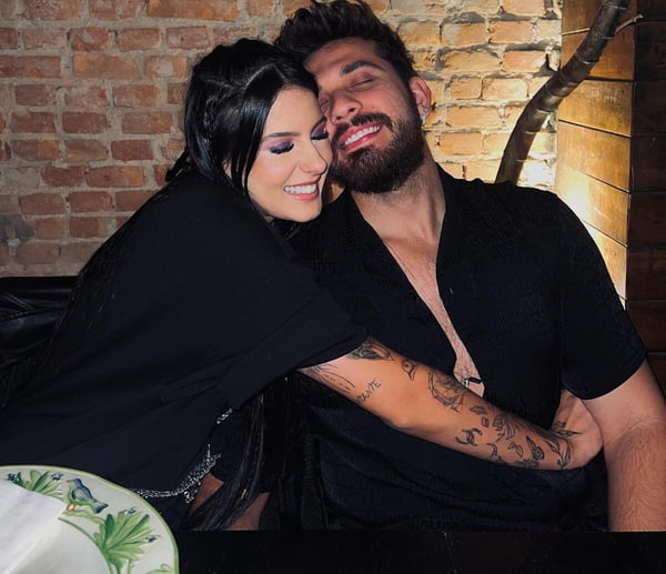 Ana Castela e Gustavo Mioto posam juntos em restaurante, ambos de looks pretos - Metrópoles