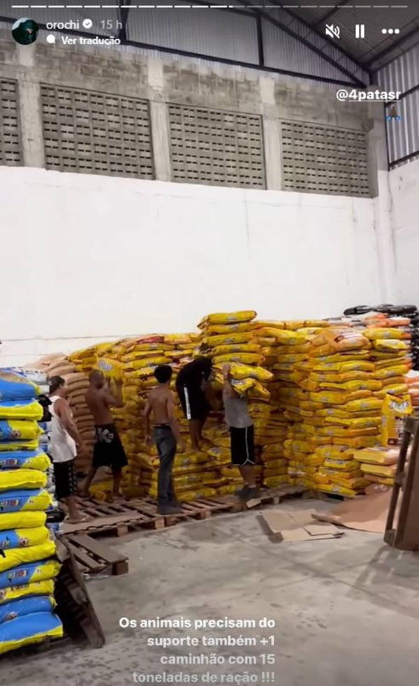 foto colorida de homens pegando sacos de ração - metrópoles