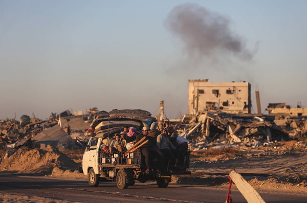 Imagem colorida mostra palestinos se deslocando de Rafah, na Faixa de Gaza, em um mini-caminhão - Metrópoles