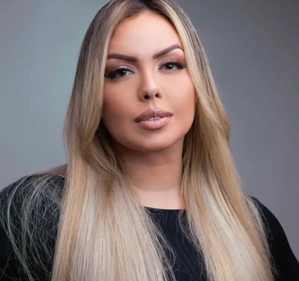 A cantora Ana Paula Vieira posa, sorridente, com um look preto - Metrópoles