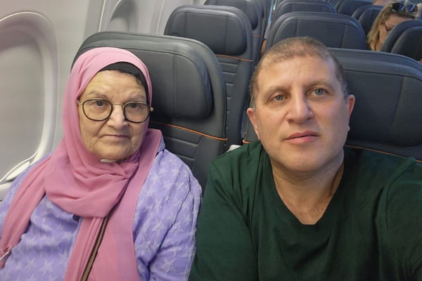 Homem de olhos claros e idosa com um hijab rosa