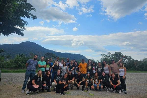 Imagem colorida de grupo de pessoas reunidas. Metrópoles