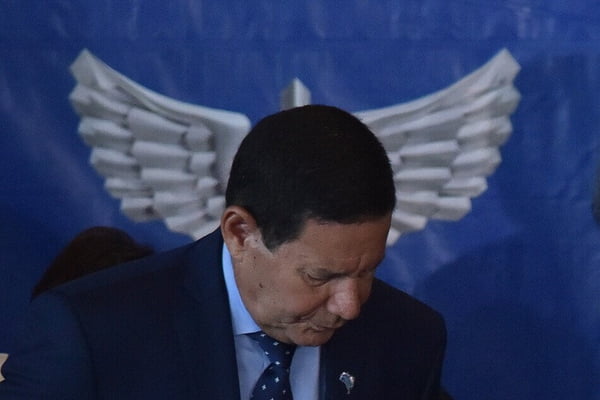 foto colorida do senador hamilton mourão com logo da aeronáutica ao fundo