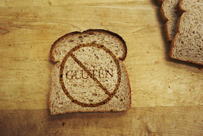 Imagem de uma fatia de pão de forma escrito glúten