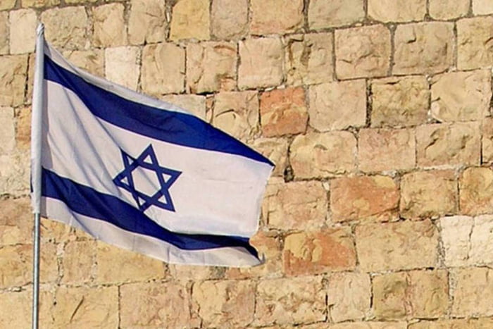 Bandeira de Israel tremulando com muro antigo ao fundo -- Metrópoles